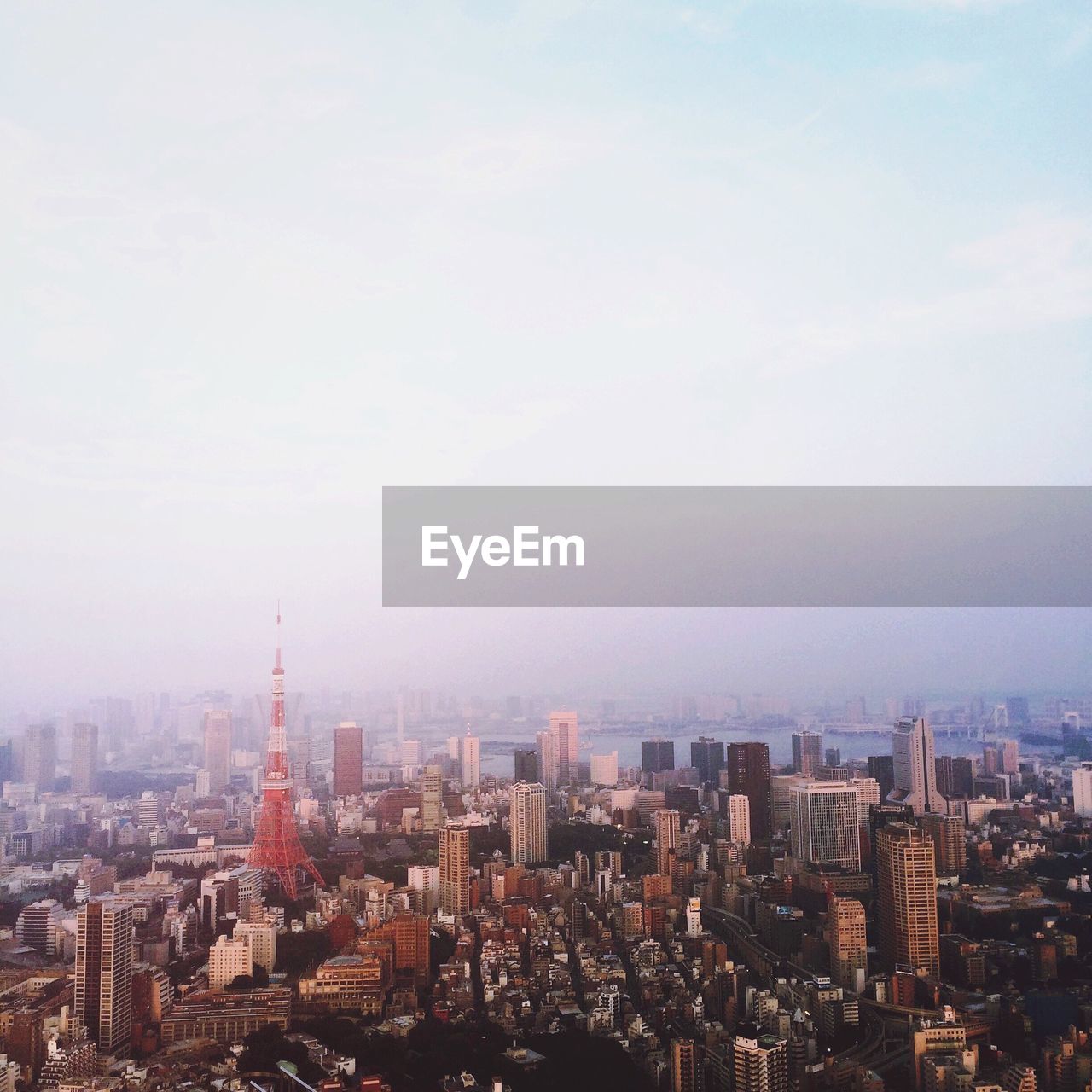 Tokyo tower and cityscape against sky at morning