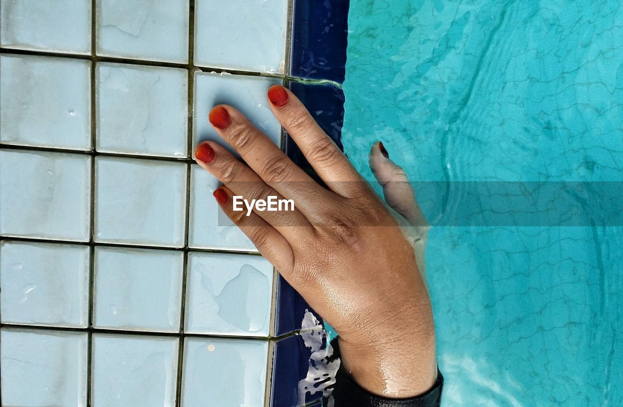 Cropped image of hand in swimming pool