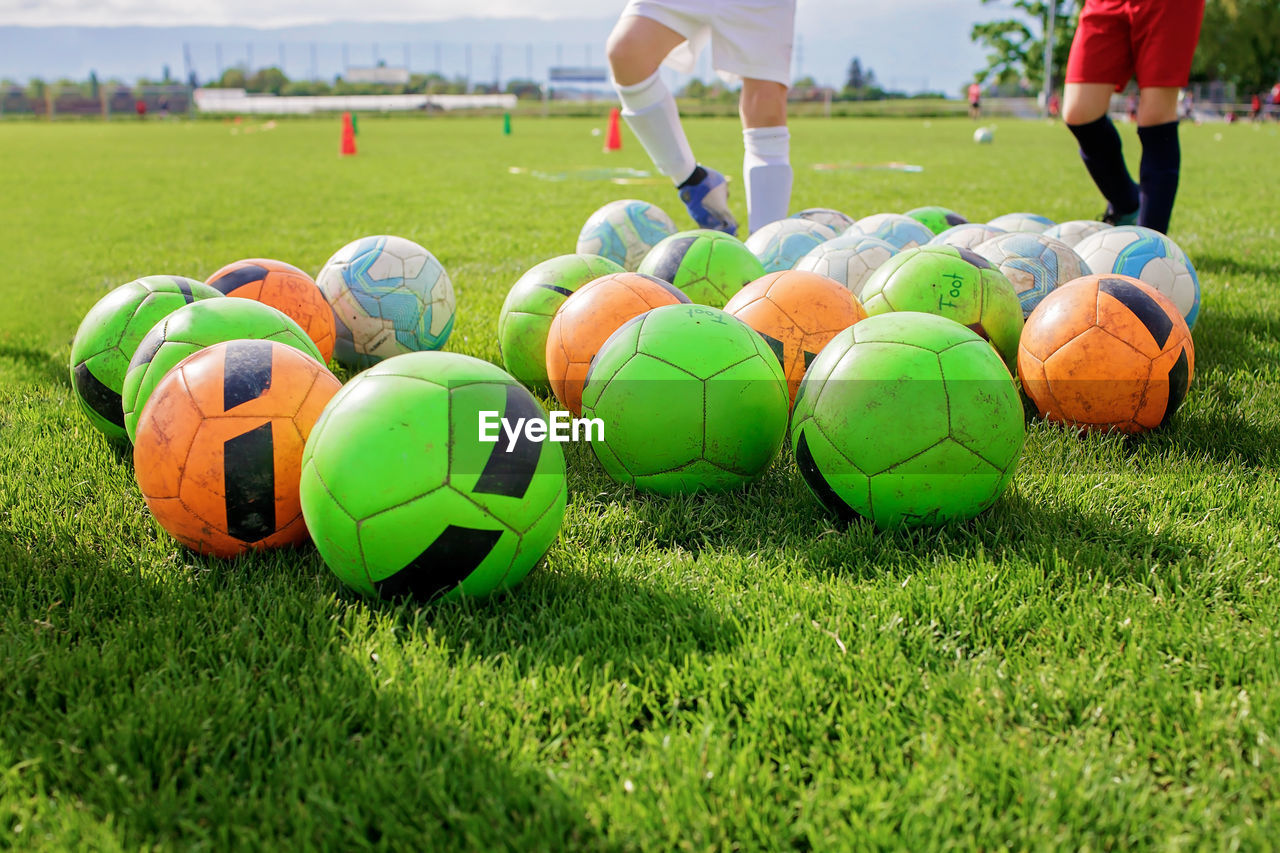 Soccer gears on green grass prepared for training in kids football academy. popular sport activity