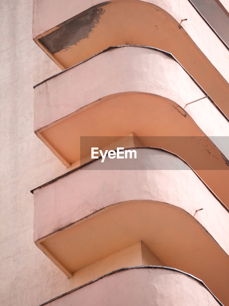 Low angle view of pastel orange corner balconies