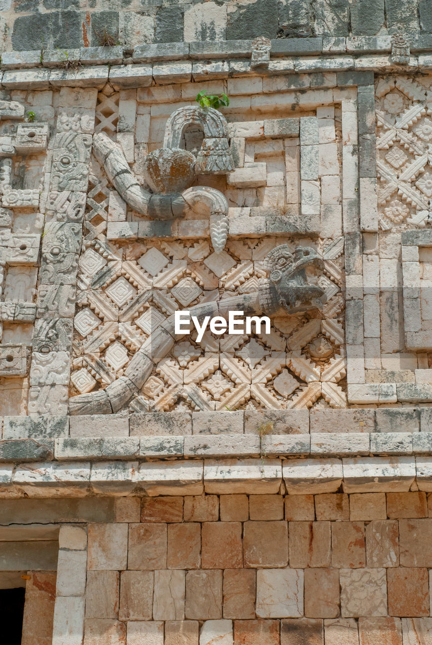 STONE WALL WITH STATUE AGAINST BRICK WALLS