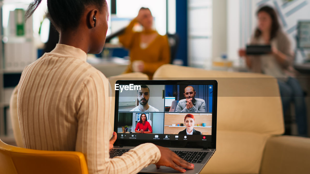 Rear view of businesswoman talking on video conference