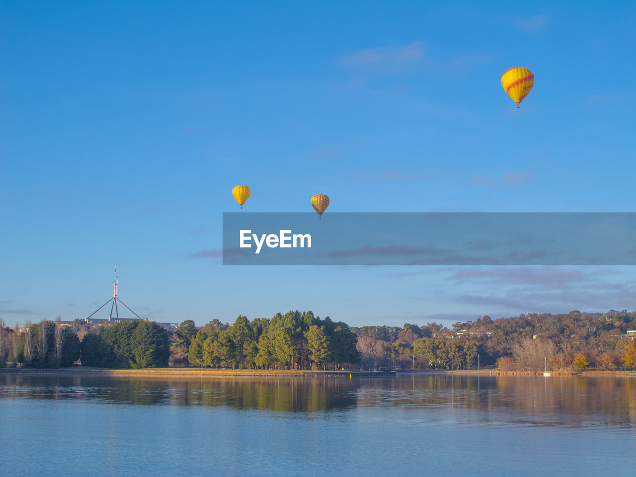 HOT AIR BALLOONS IN RIVER AGAINST SKY