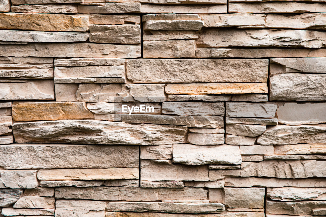 Stone lined with granite wall, sandstone, stone background wall. facing stone, rock texture