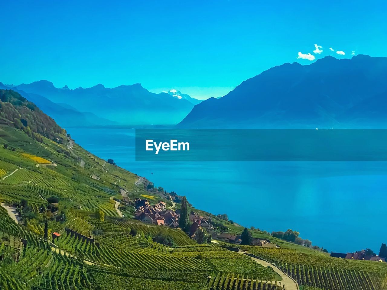 Scenic view of sea and mountains against blue sky