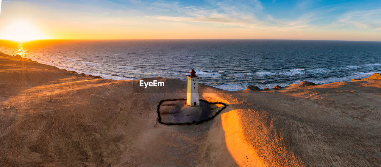 Rubjerg knude fyr lighthouse in sunset from drone