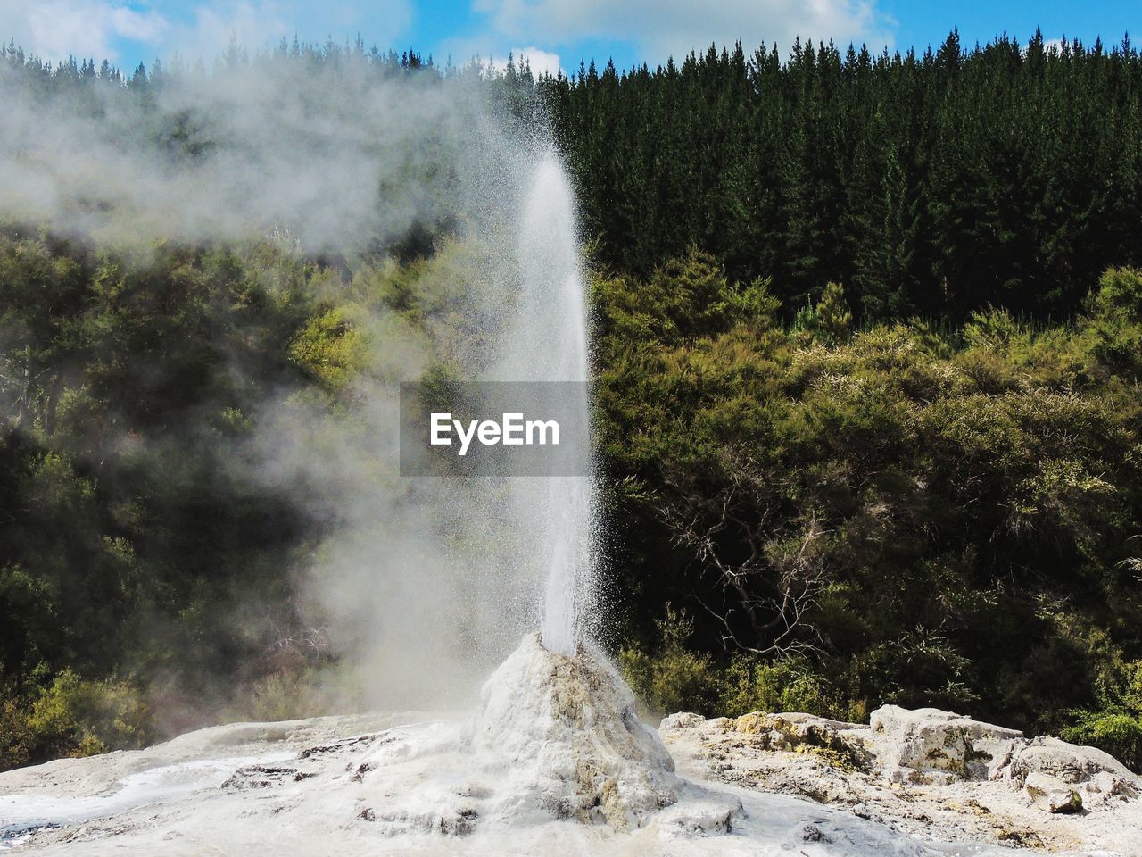 Scenic view of geyser erupting