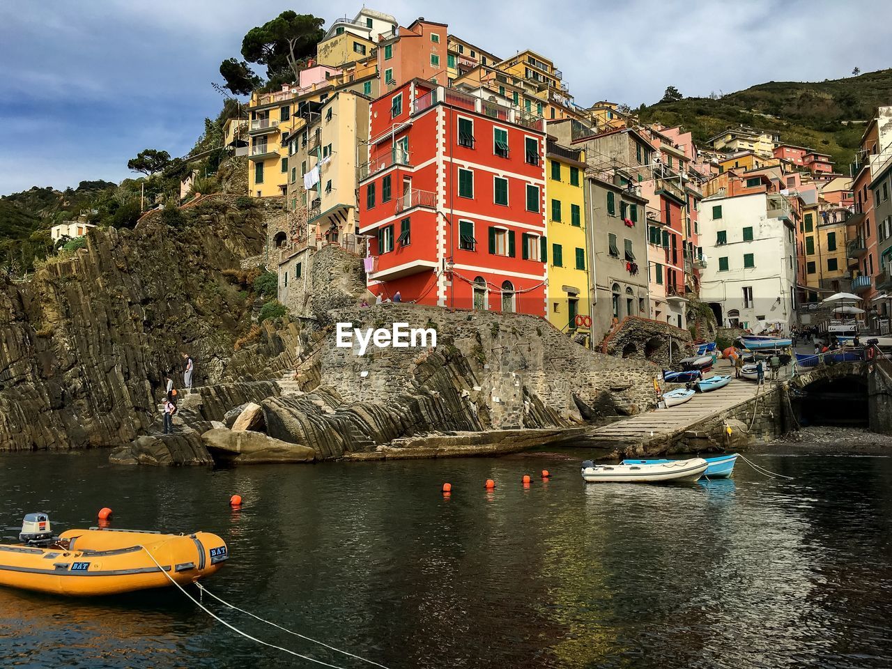 Boats on river by buildings at cinque terre