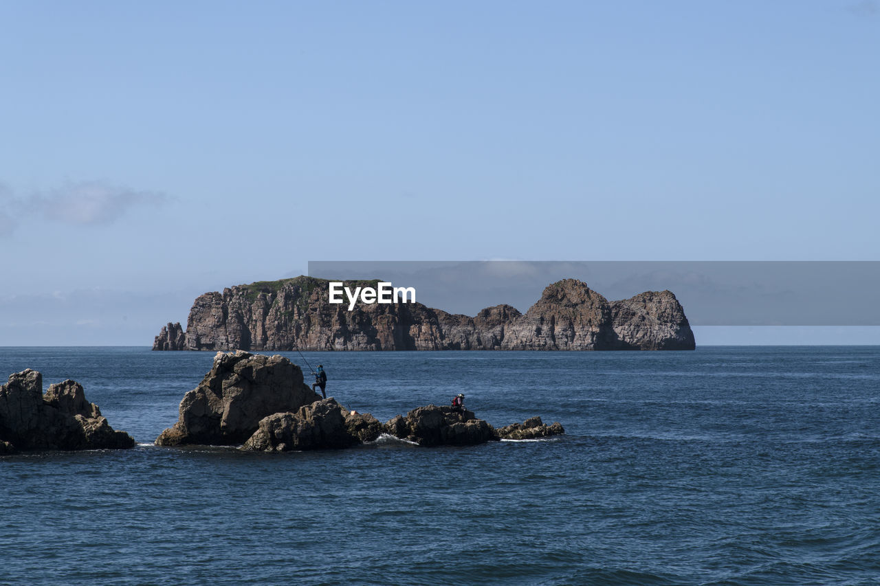 Scenic view of rocks in sea against sky