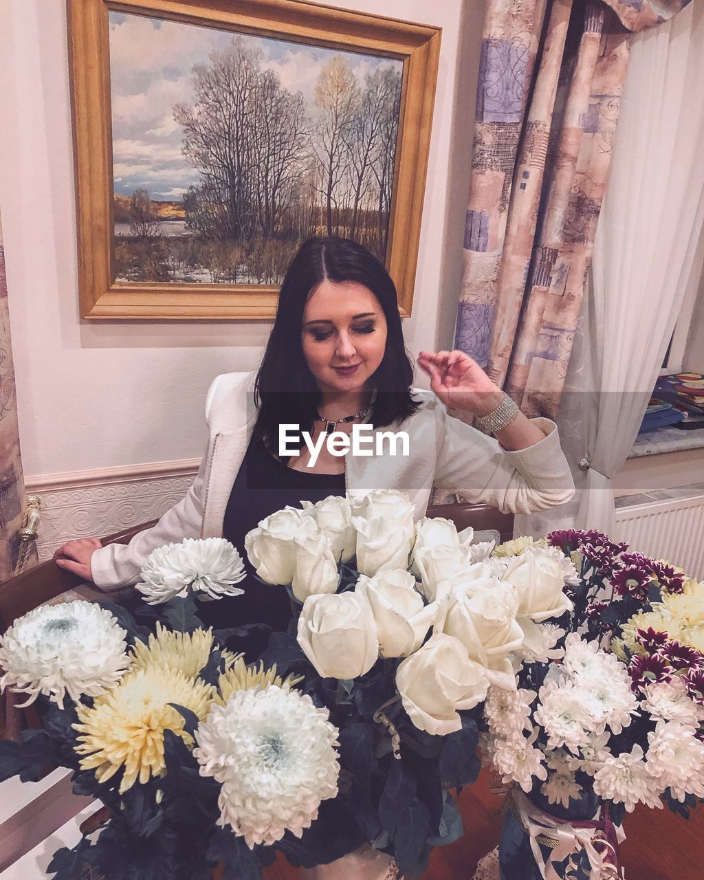 High angle view of woman sitting by bouquets at home