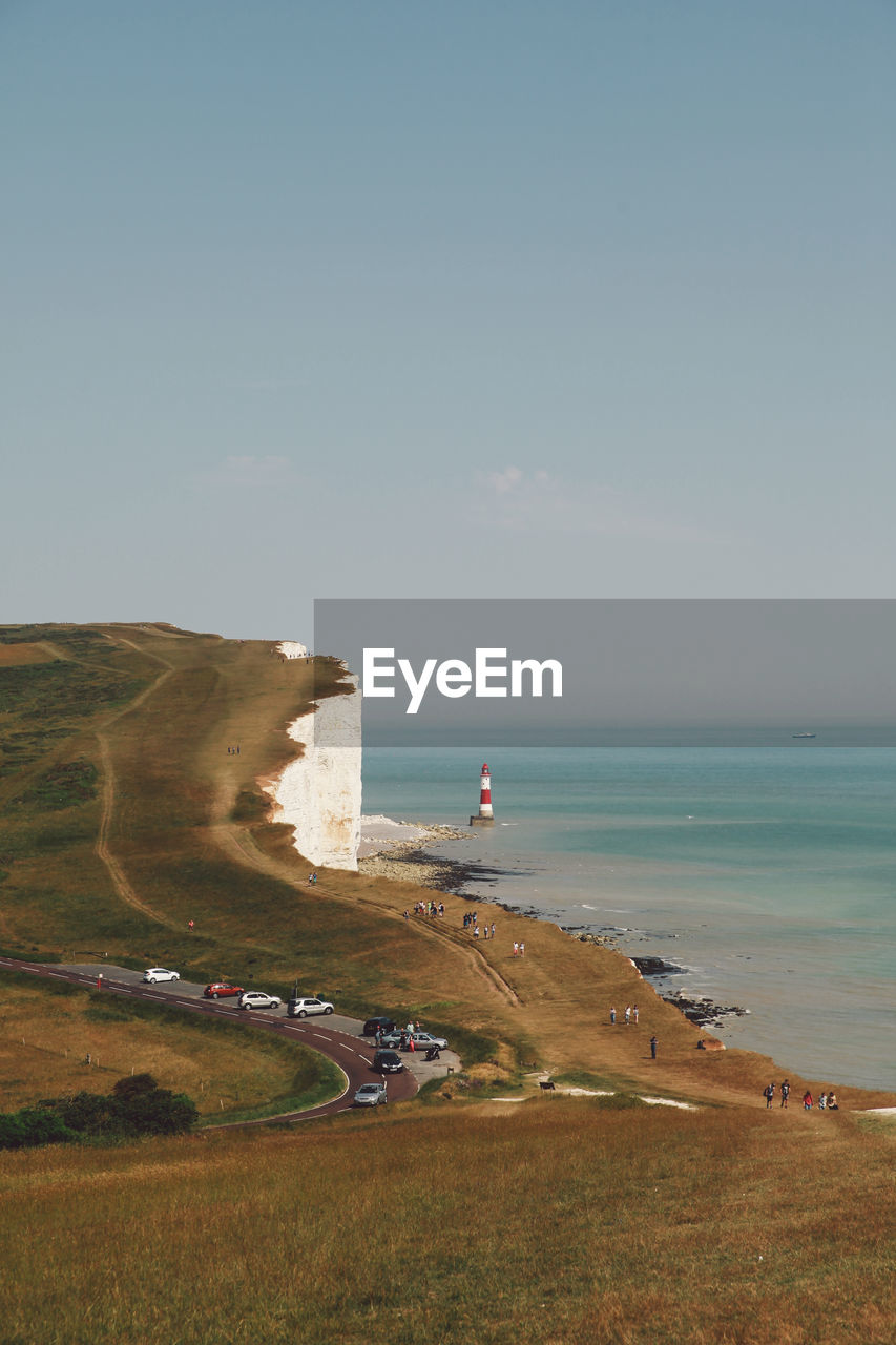 Scenic view of sea by cliff against sky