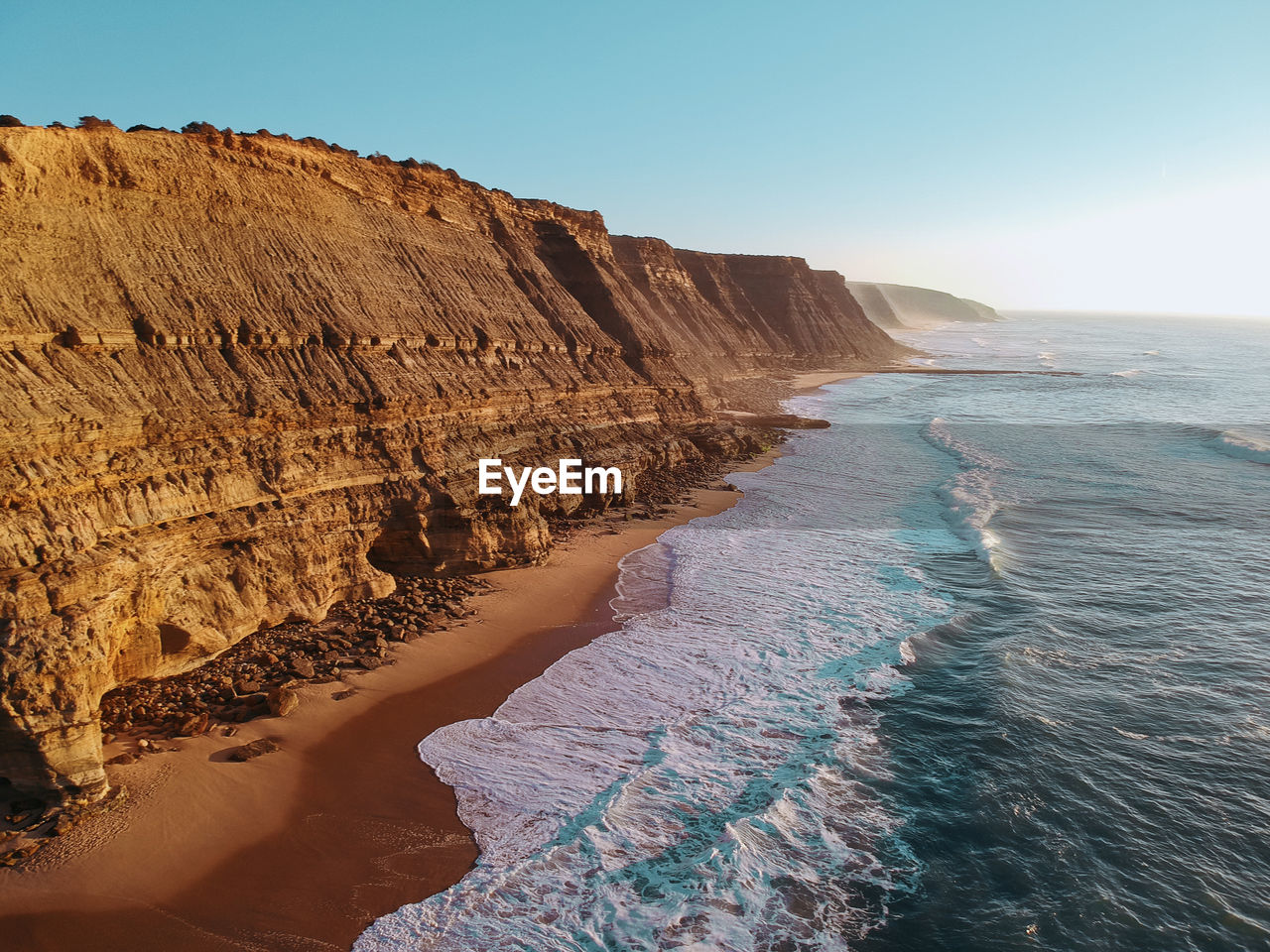 Scenic view of sea by rock formation against sky