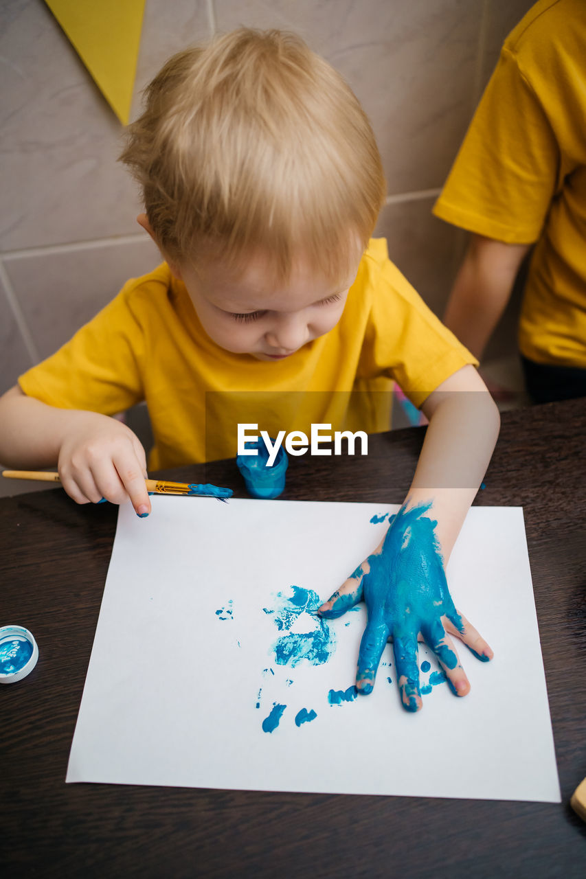 Hands of painting little boy and the table for creativity.hand kids painting. high quality photo