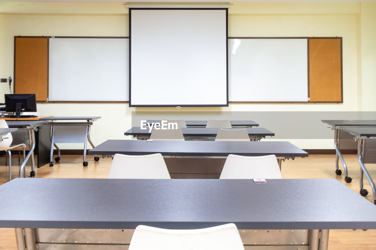 EMPTY CHAIRS AND TABLES IN FRONT OF AN ABANDONED ROOM