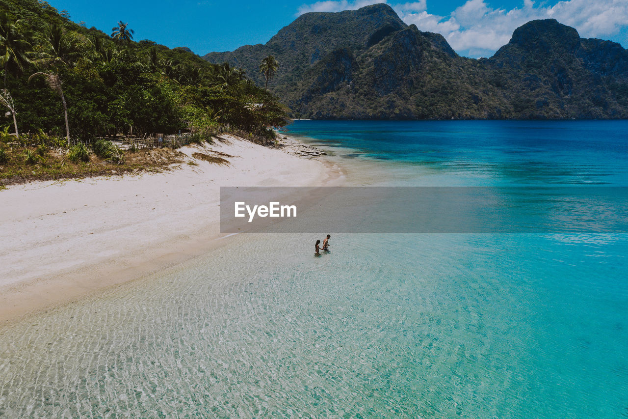 Drone view of couple at beach on sunny day