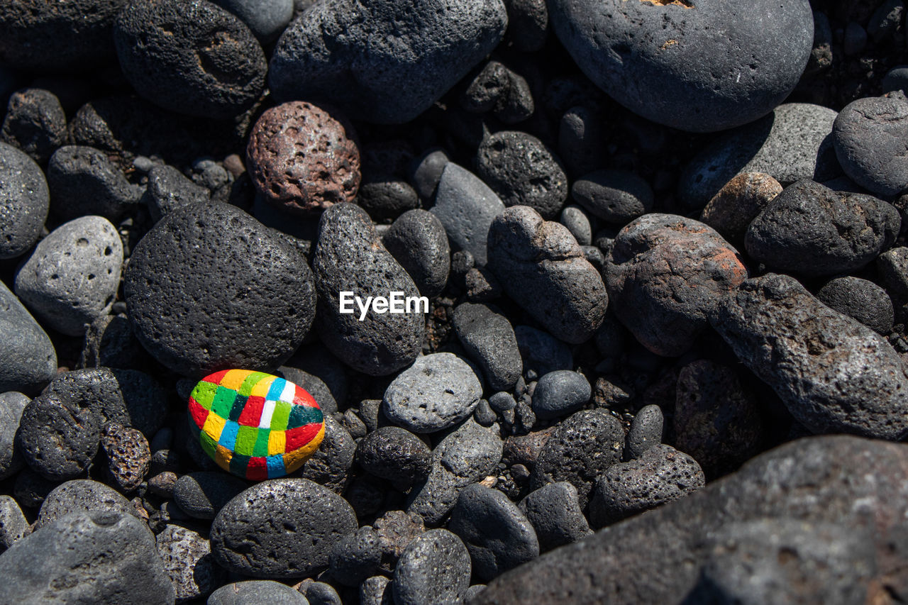 HIGH ANGLE VIEW OF STONES AND PEBBLES ON ROCKS