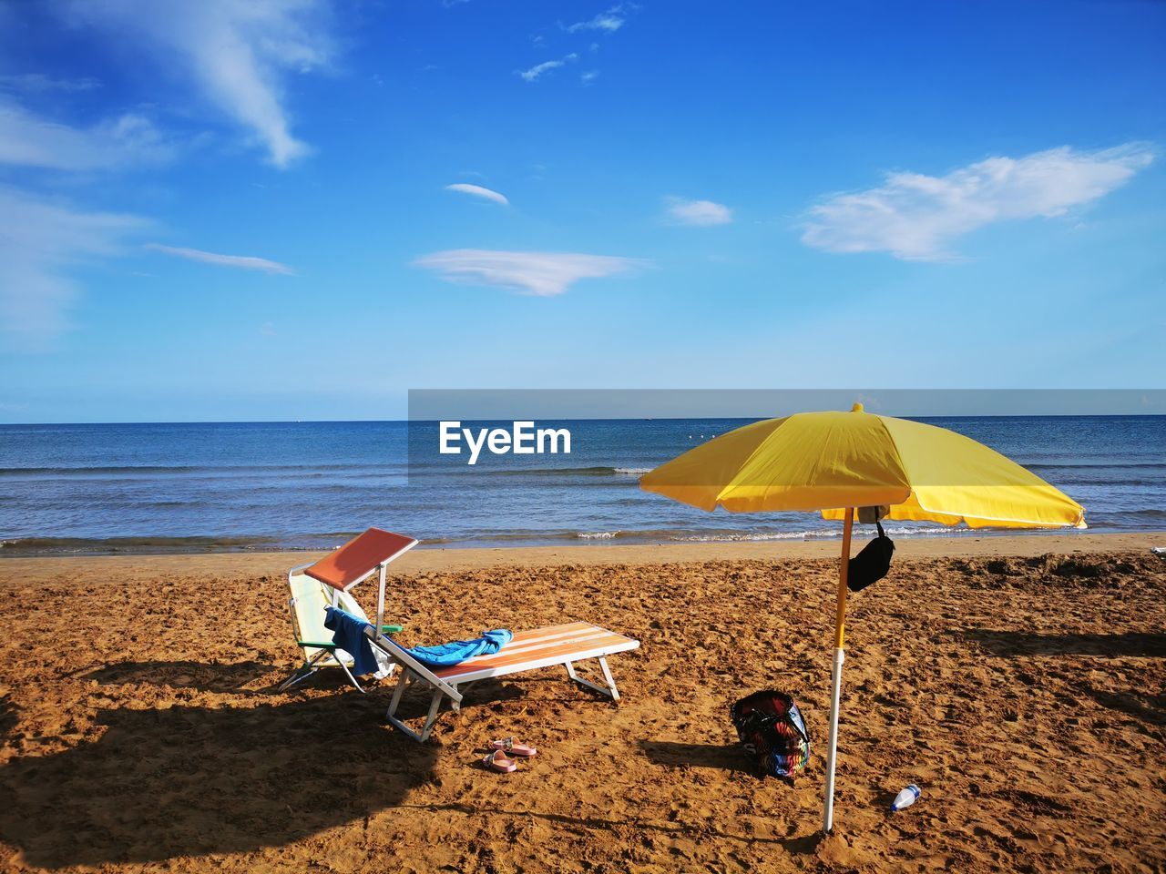 beach, land, water, sea, sky, sand, umbrella, nature, horizon over water, chair, horizon, ocean, vacation, summer, trip, beauty in nature, shore, parasol, holiday, tranquility, scenics - nature, beach umbrella, cloud, body of water, tranquil scene, relaxation, coast, protection, sunshade, shade, blue, travel destinations, sunlight, seat, lounge chair, idyllic, day, travel, security, deck chair, outdoors, no people, absence, outdoor chair, sun, coastline, tourism, sunny, environment, tropical climate, urban skyline, leisure activity, copy space