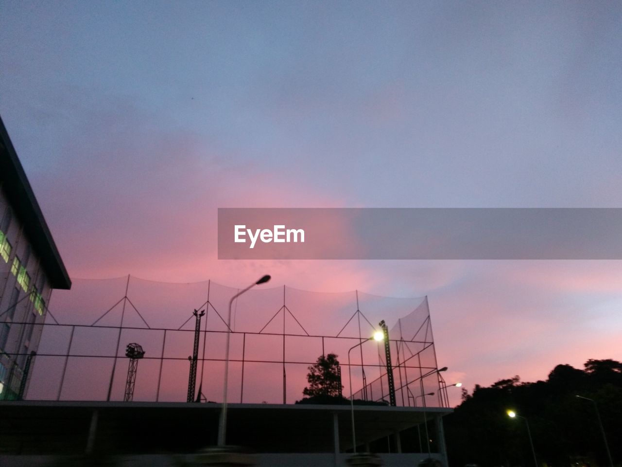 LOW ANGLE VIEW OF BUILDING AGAINST SKY AT SUNSET