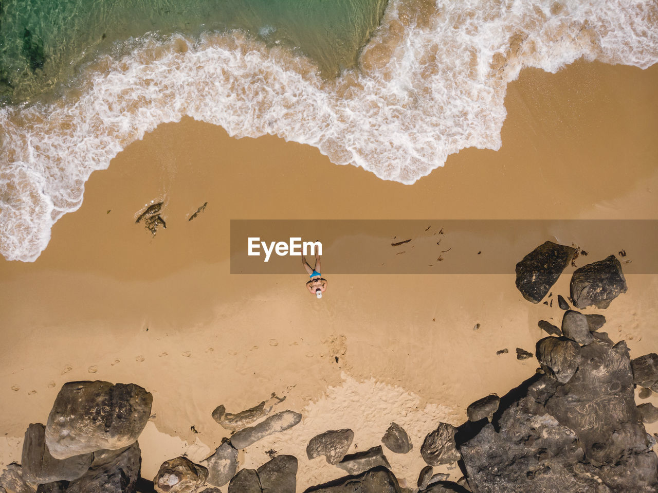 Aerial view of man lying on the beach