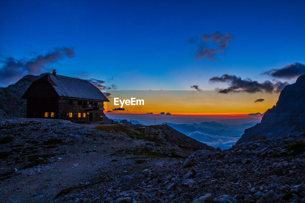 HOUSE ON MOUNTAIN AGAINST SKY DURING WINTER