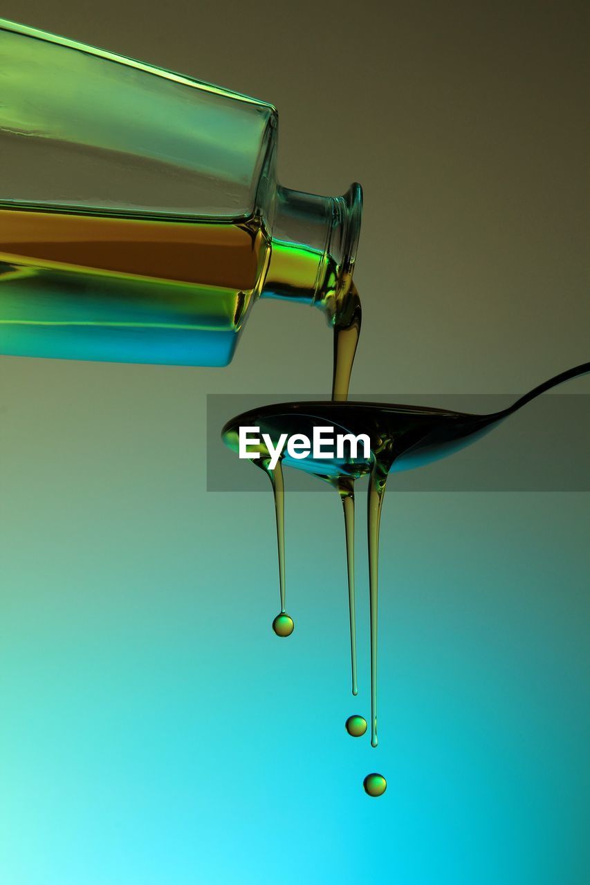 Close-up of olive oil pouring on spoon