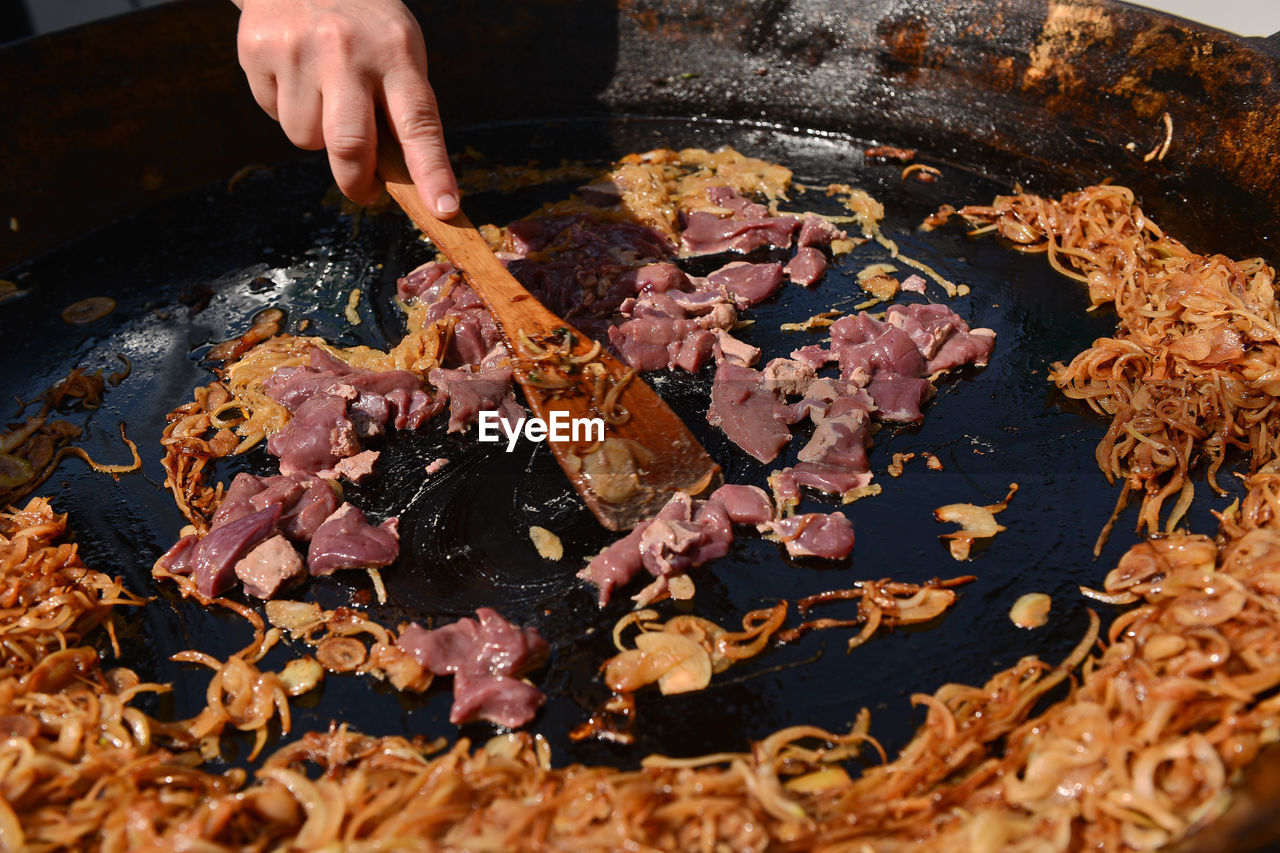 Meat and fried onions on cooking pan