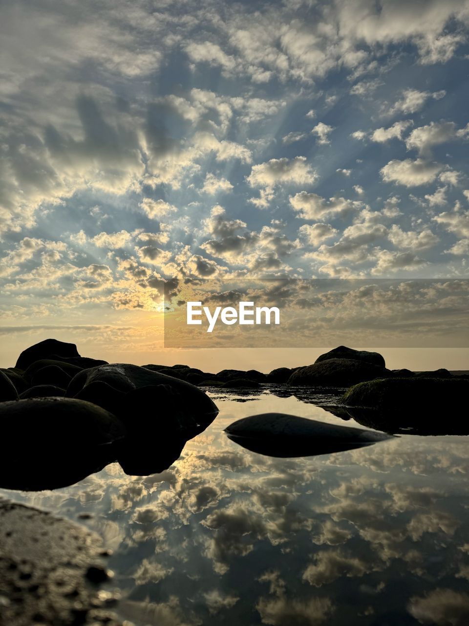 sky, cloud, reflection, sunlight, sunset, horizon, nature, sea, water, beauty in nature, scenics - nature, tranquility, dawn, silhouette, tranquil scene, outdoors, no people, evening, wave, ocean, light, environment, rock, sun, land, darkness, coast