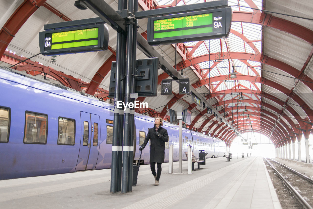 Man checking timetable at train station