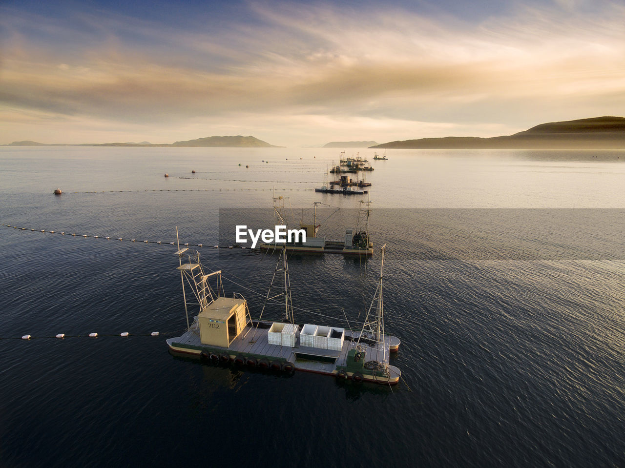 High angle view of ship in sea against cloudy sky during sunset