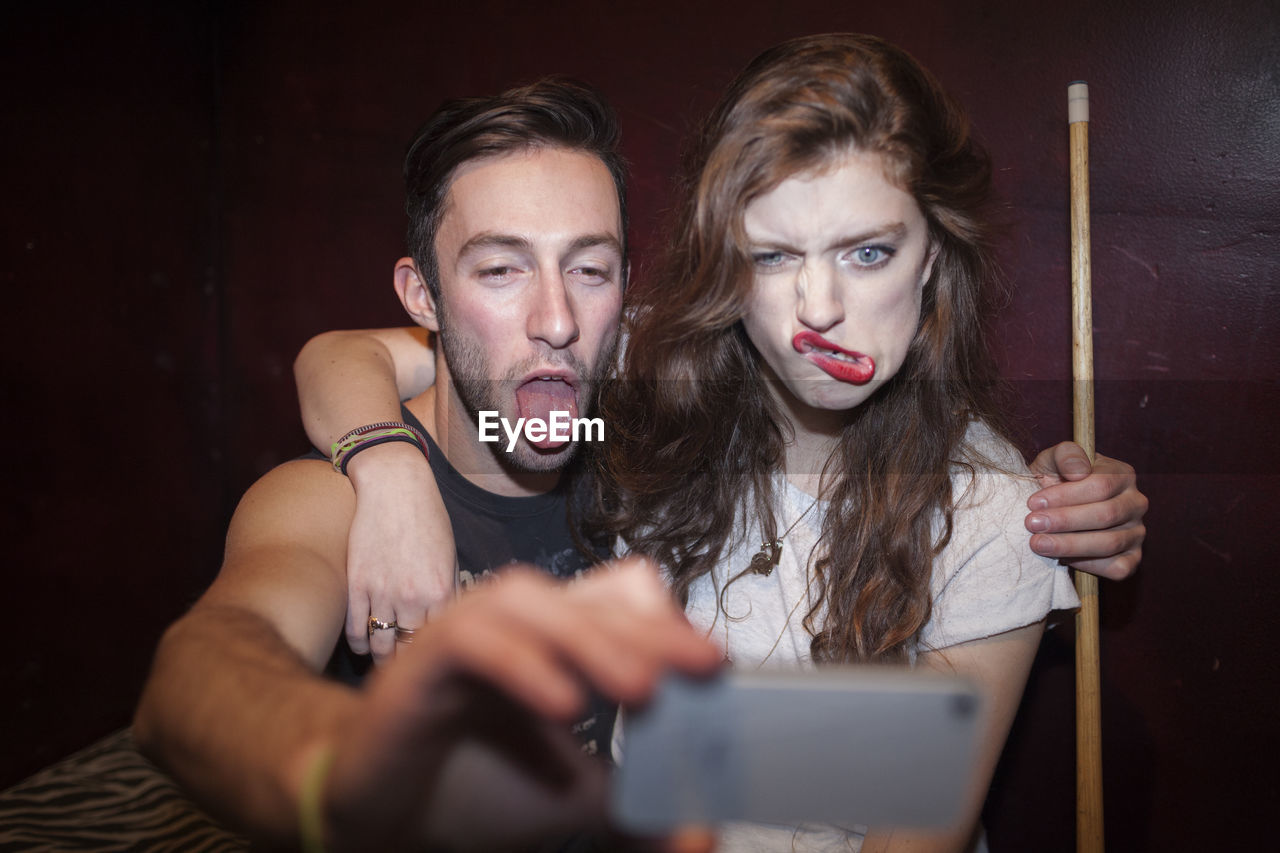 Young couple taking selfies on a cell phone