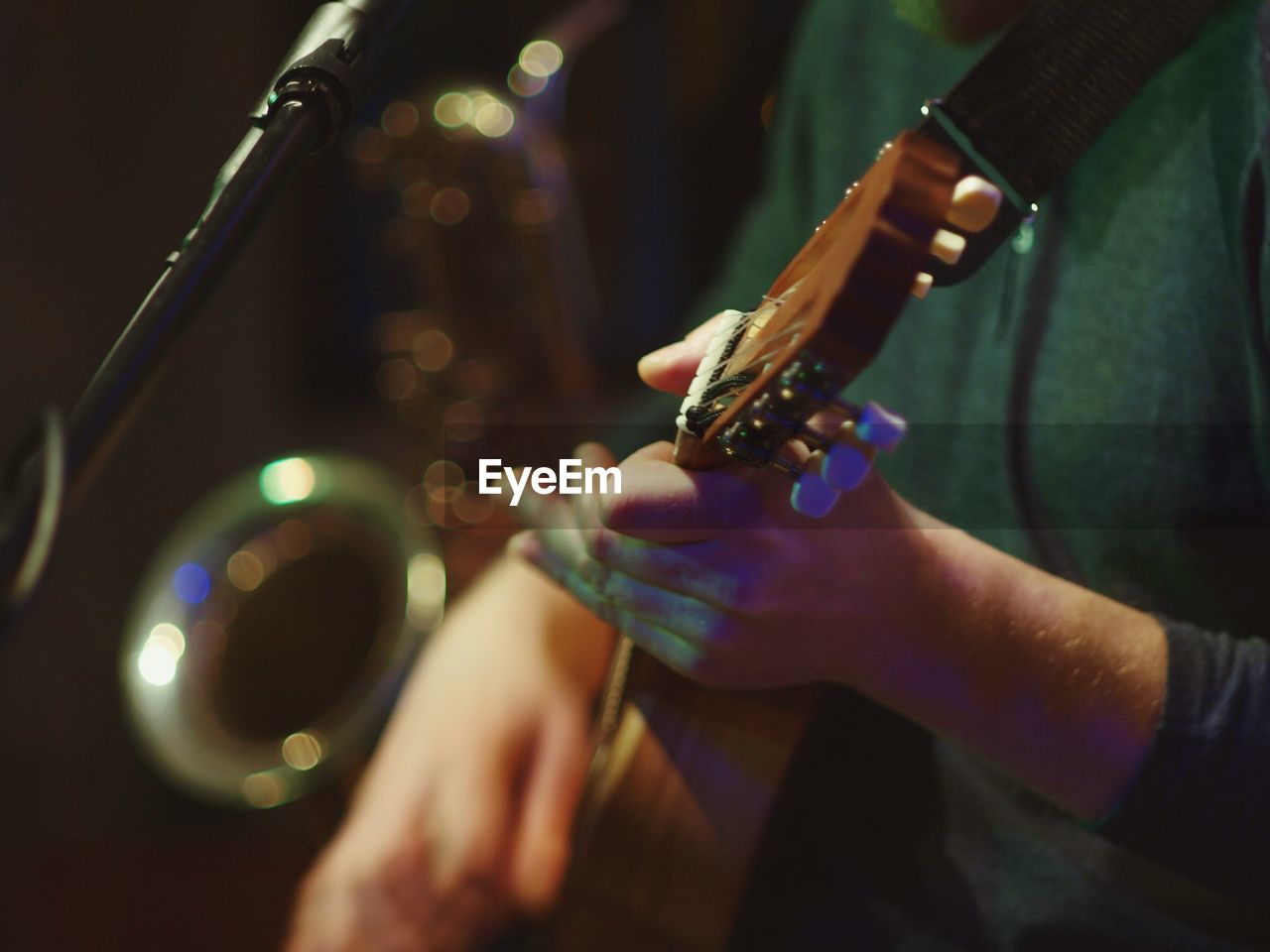 CLOSE-UP OF HAND HOLDING GUITAR