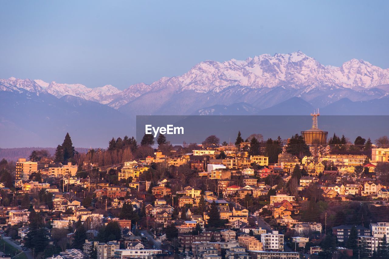 Aerial view of townscape and mountains against sky