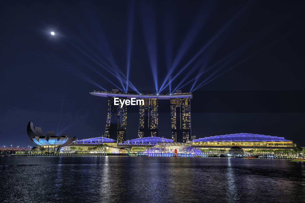 ILLUMINATED MODERN BRIDGE OVER RIVER AT NIGHT