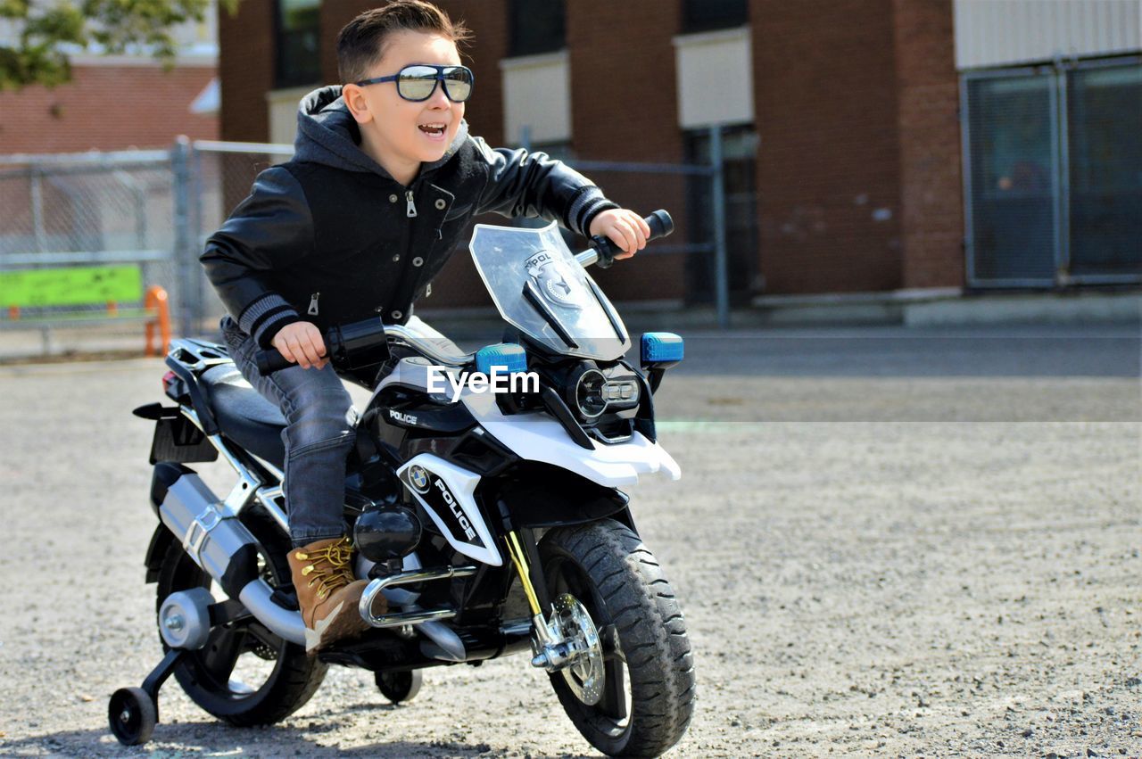 Boy riding toy bike on road