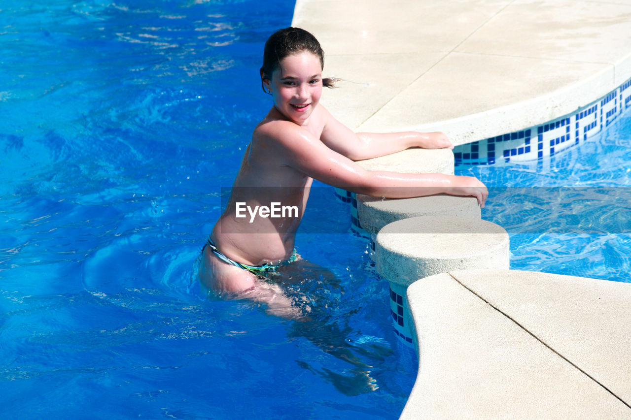 High angle view of happy teenage boy in swimming pool during summer