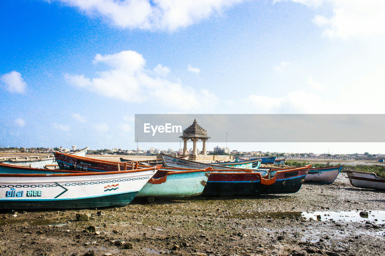 Boats moored on beach against sky