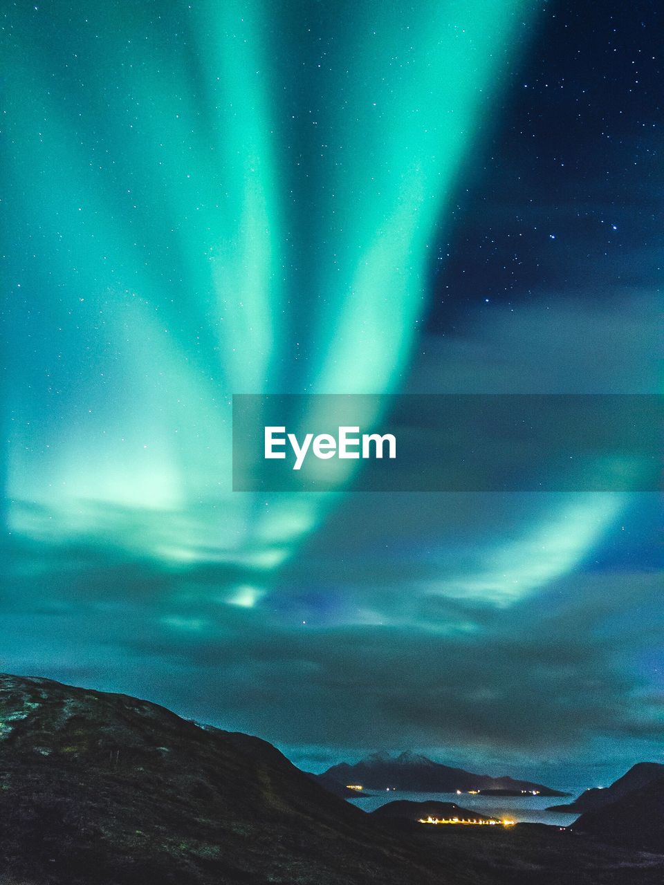 Scenic view of mountain against dramatic sky at night