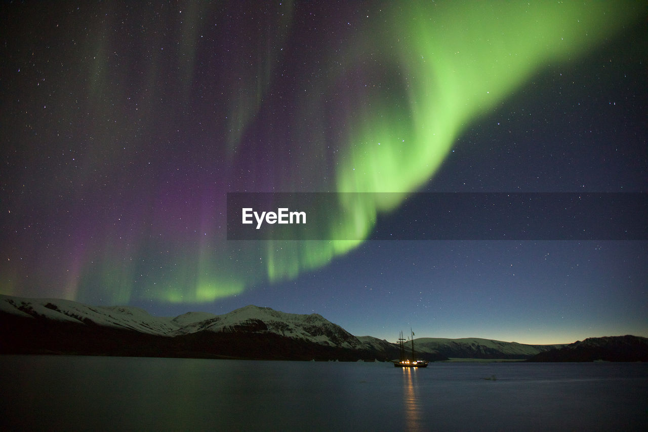 Scenic view of lake against sky during aurora borealis