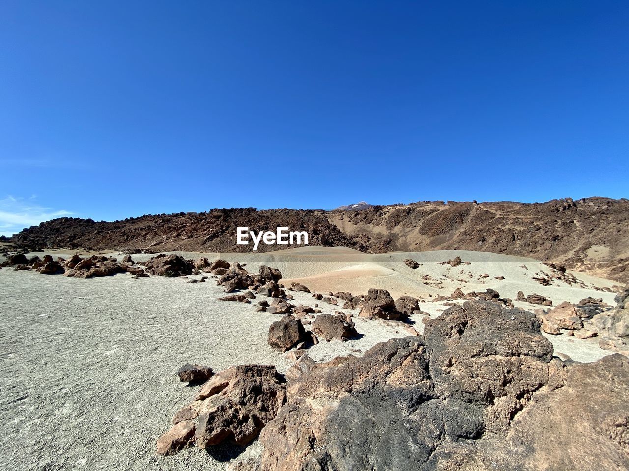 Scenic view of desert against clear blue sky