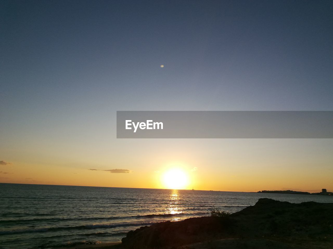 SCENIC VIEW OF SEA AGAINST ORANGE SKY