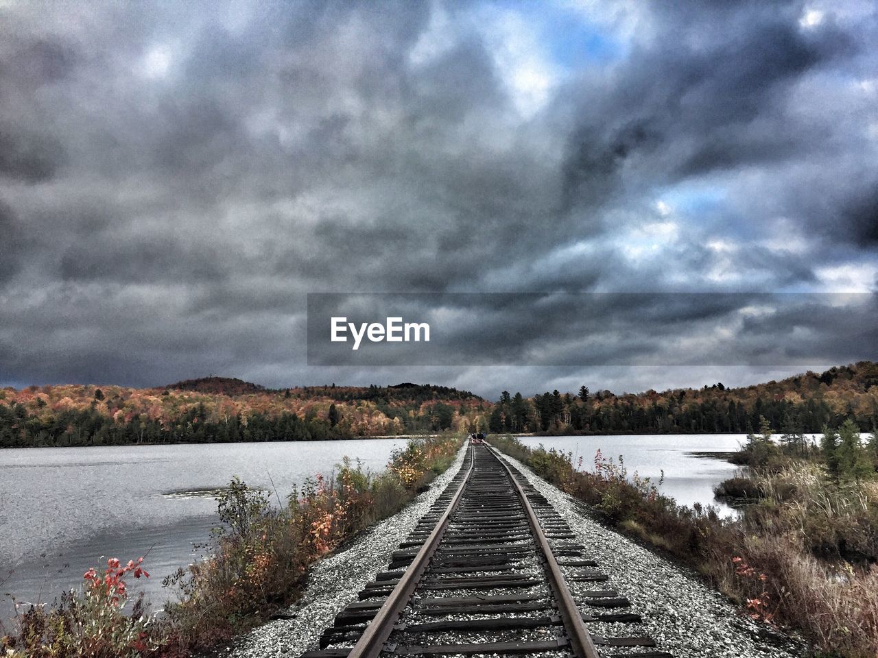 RAILROAD TRACKS AGAINST CLOUDY SKY