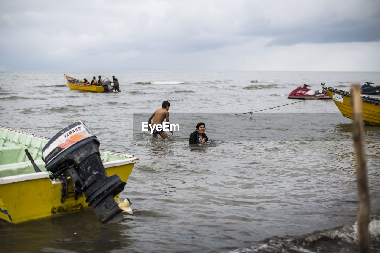 PEOPLE ON BOAT AGAINST SEA