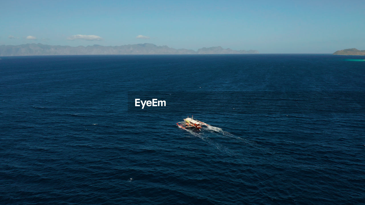 BOAT IN SEA AGAINST SKY