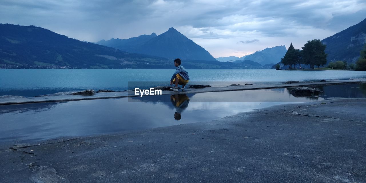 Full length of boy in lake against sky in interlaken- switzerland