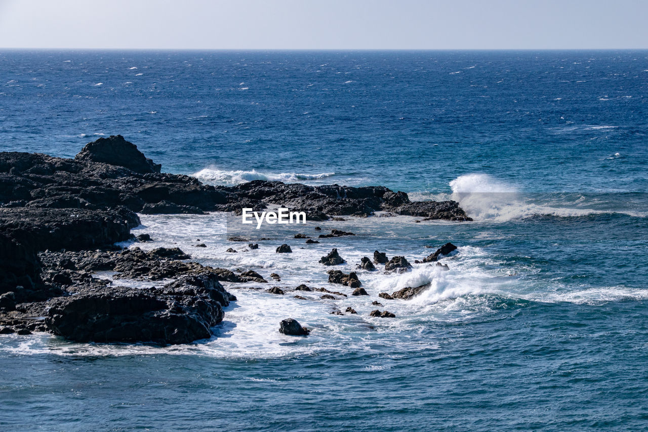 sea, water, ocean, wind wave, beauty in nature, scenics - nature, horizon, wave, horizon over water, rock, nature, sky, land, coast, beach, motion, shore, no people, blue, body of water, outdoors, day, tranquility, tranquil scene, sports, seascape, non-urban scene, idyllic, islet, rock formation, water sports, mammal, terrain, travel destinations, clear sky, cliff