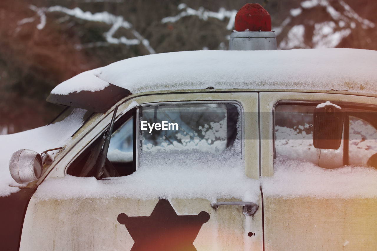 CLOSE-UP OF SNOW COVERED CAR ON ROAD