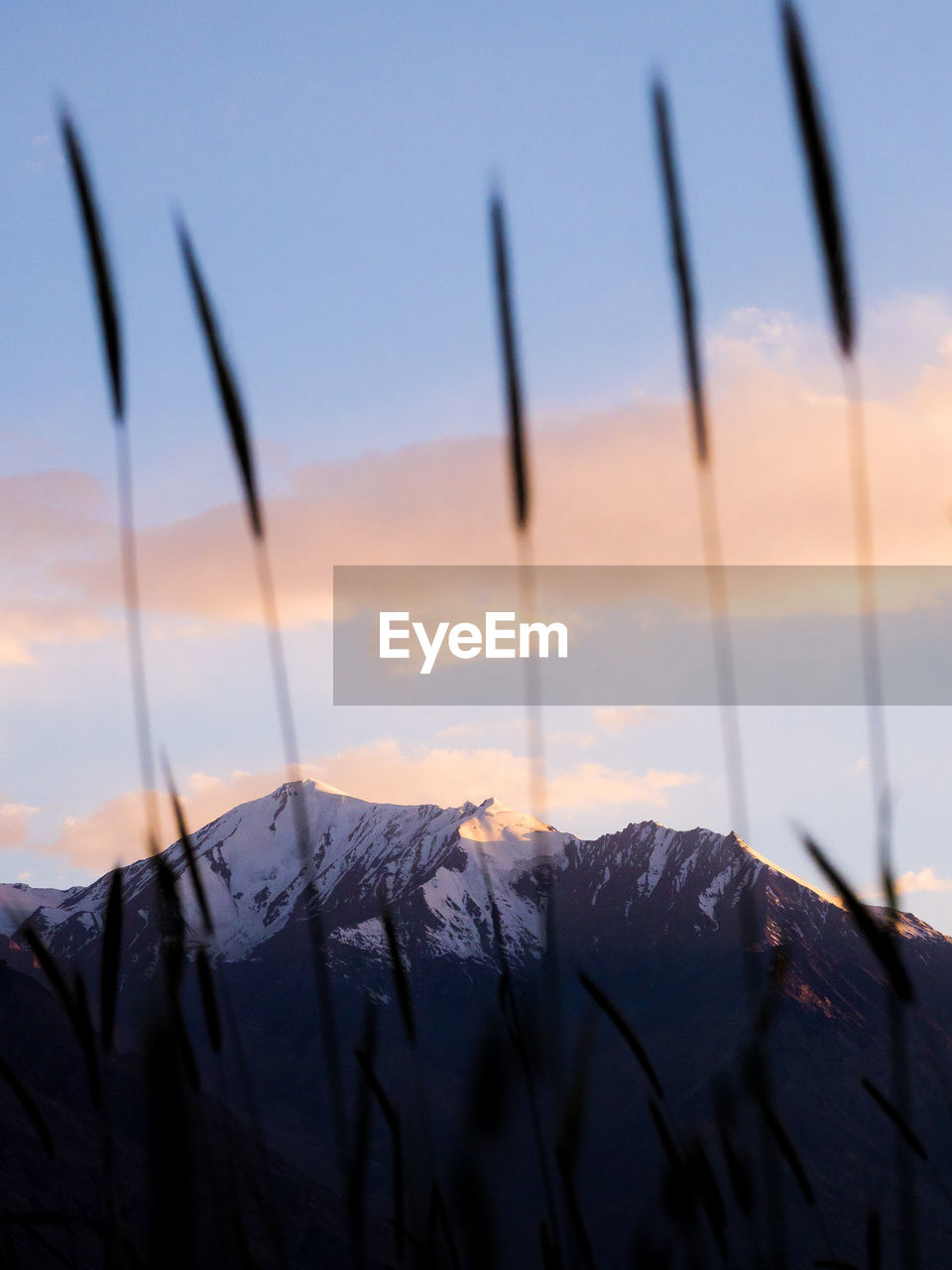Close-up of snowcapped mountains against sky during sunset