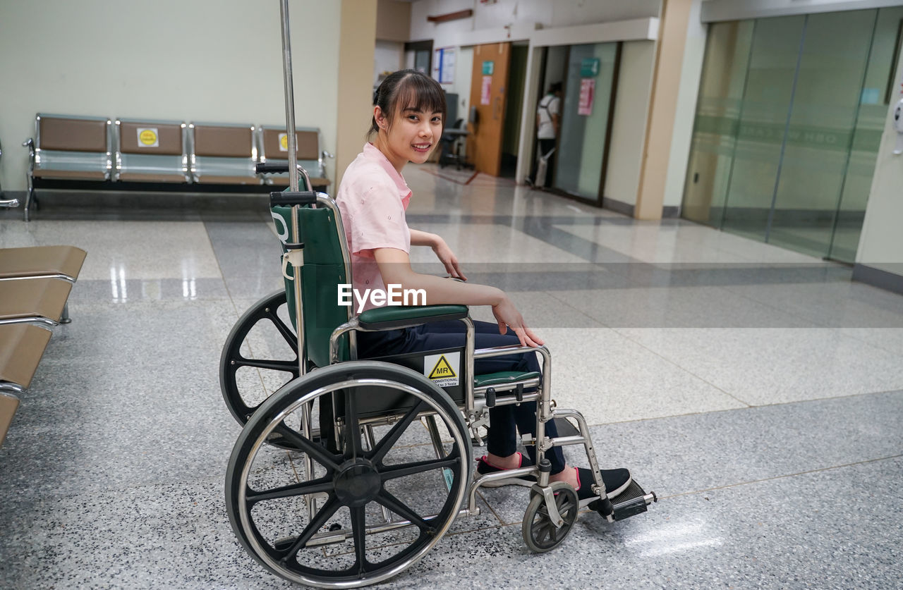 PORTRAIT OF SMILING GIRL SITTING ON FLOOR