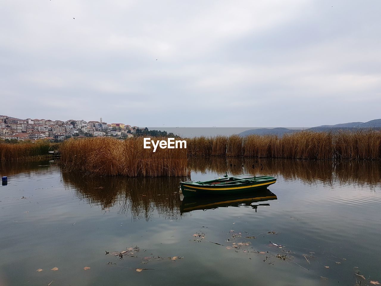 Boat floating on lake against sky