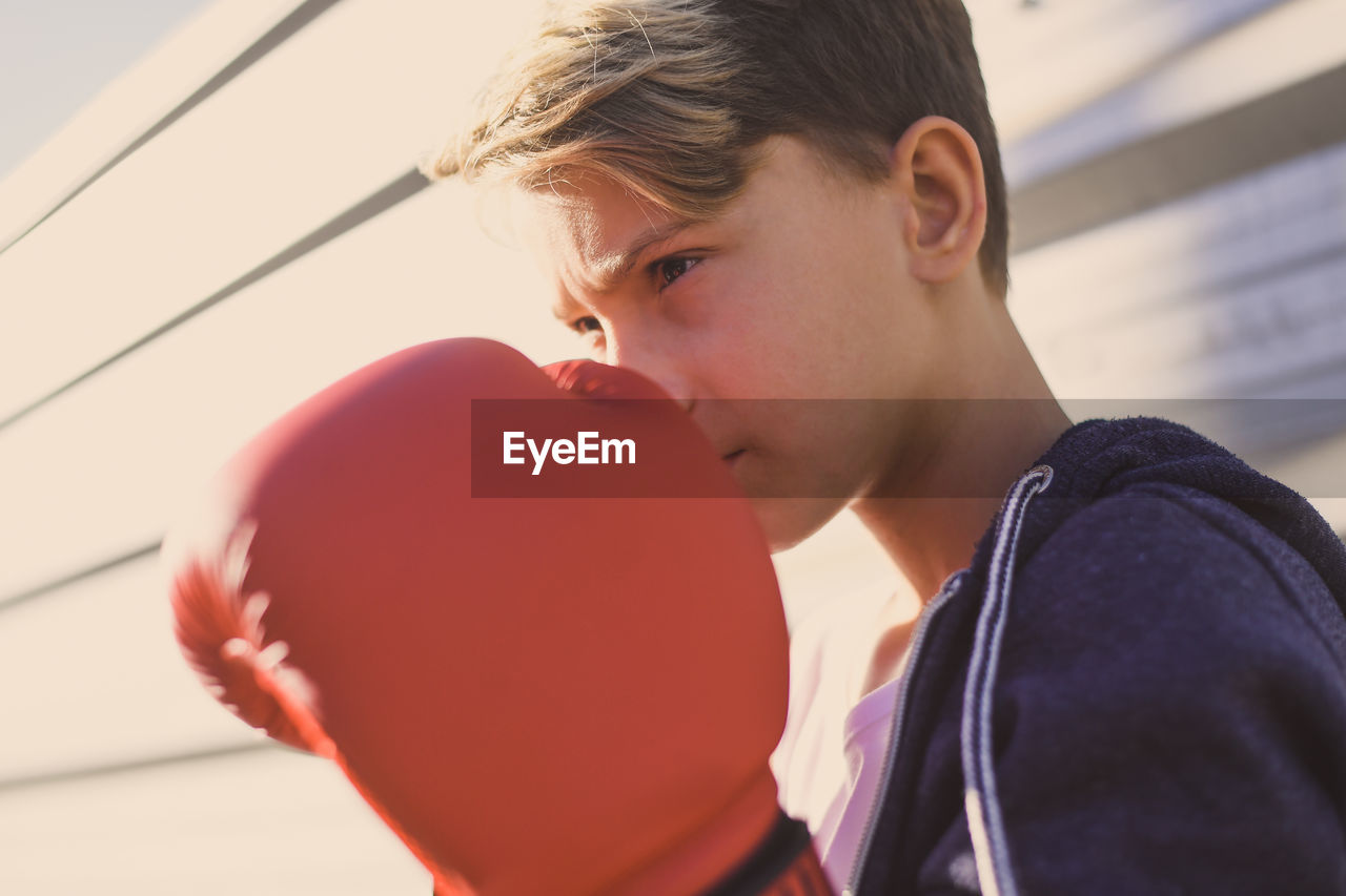 Close-up of boy wearing boxing gloves